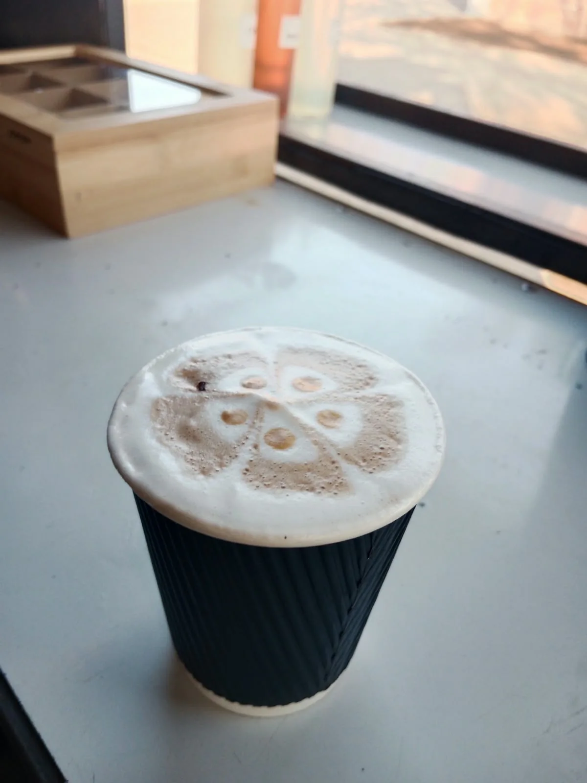 Freshly made coffee in a black takeaway cup